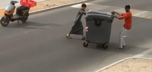 <p><strong>"لحظة إنسانية مؤثرة في العين: طفل ومقيم يتعاونان لإبعاد حاوية عن الطريق"</strong></p> 1 "لحظة إنسانية مؤثرة في العين: طفل ومقيم يتعاونان لإبعاد حاوية عن الطريق"